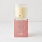 Hudson Grace Savannah scented candle in a frosted glass vessel with HG logo, on a pink box.
