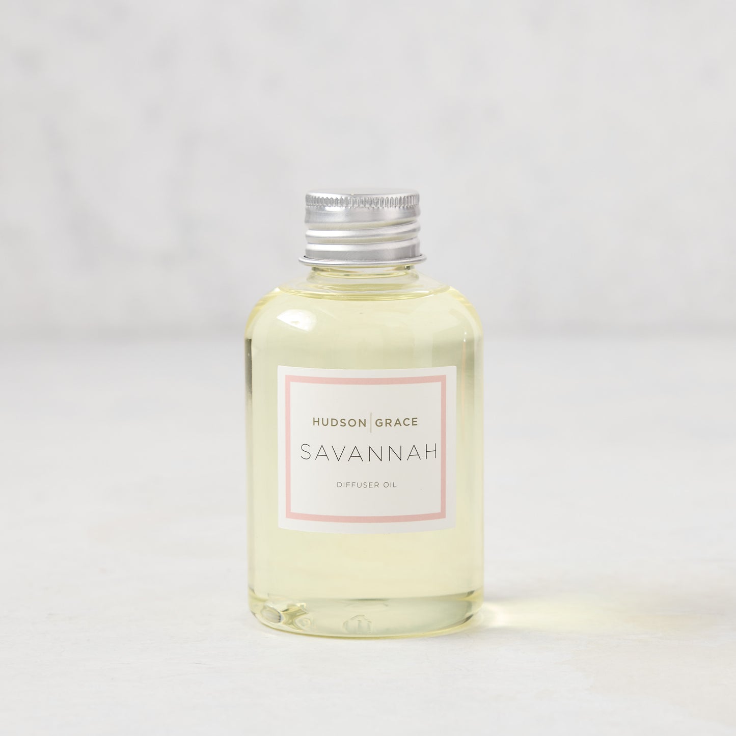 Hudson Grace Savannah scented reed diffuser oil refill, 4oz clear glass bottle with silver cap and pink label.