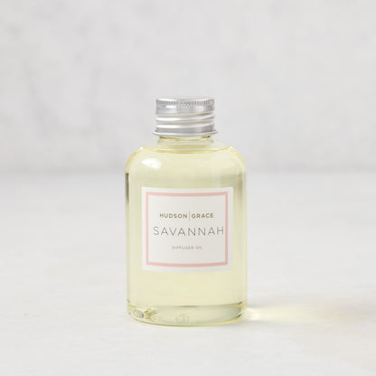 Hudson Grace Savannah scented reed diffuser oil refill, 4oz clear glass bottle with silver cap and pink label.