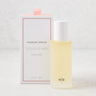 Hudson Grace Savannah Scented Room Spray: 5.08 oz clear glass bottle with white cap next to a white box with pink ribbon.