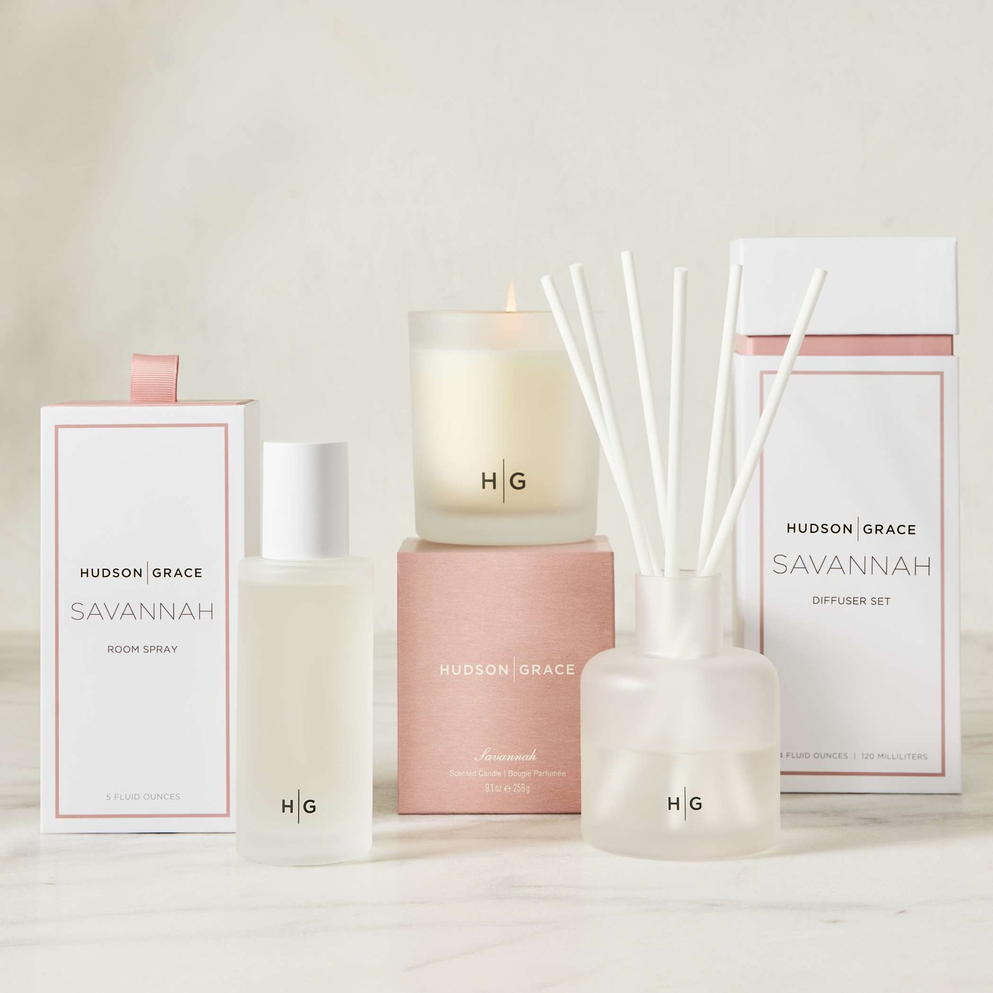 Hudson Grace Savannah scented candle, room spray, and diffuser set in frosted glass with white and pink packaging.