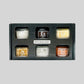 Hudson Grace Spiceology Infused Salt Variety Pack featuring six unique gourmet seasoning jars in a black gift box.
