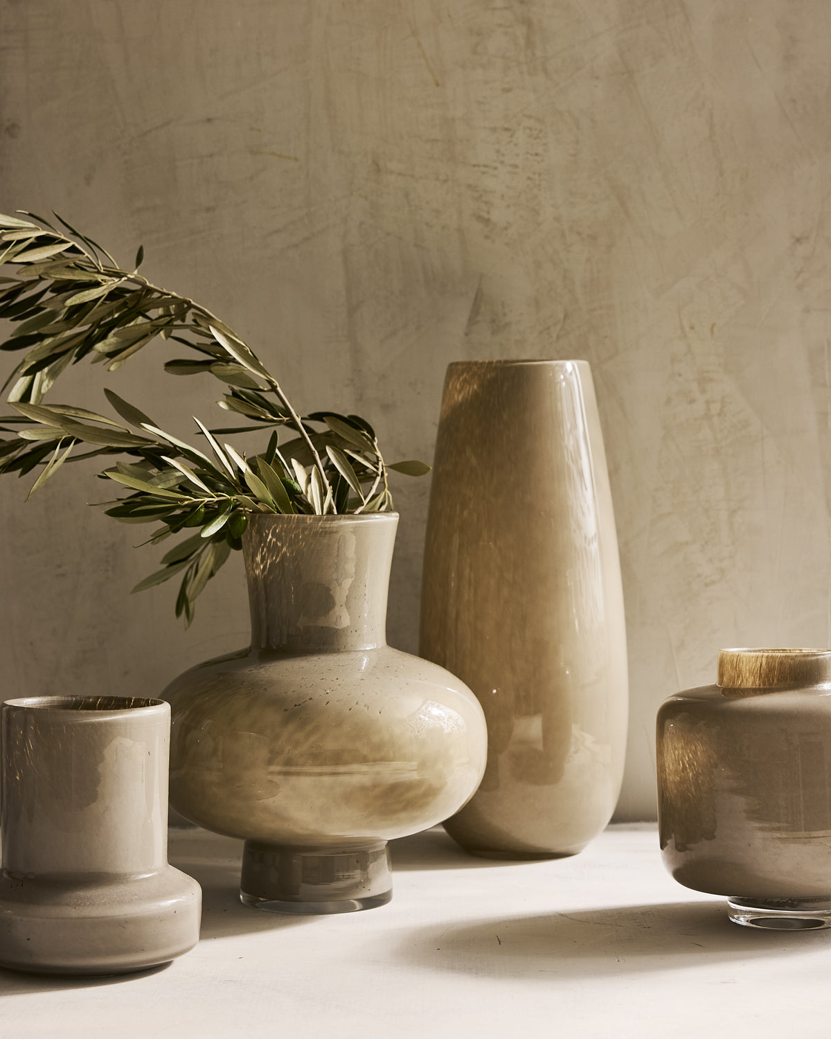 Hudson Grace taupe glass vases in assorted shapes styled with olive branches