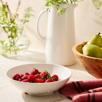 Hudson Grace white ceramic berry bowl with raspberries and strawberries on a marble counter.