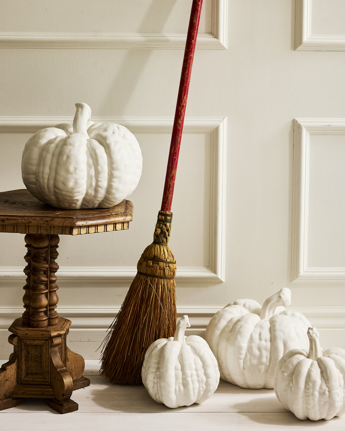 Hudson Grace white ceramic pumpkins styled with a broom for fall and Halloween decorating