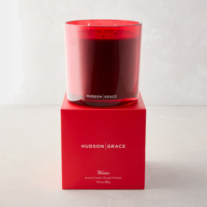 Hudson Grace Winter Scented 3-Wick Candle in a red glass vessel with red wax, on its matching red gift box.