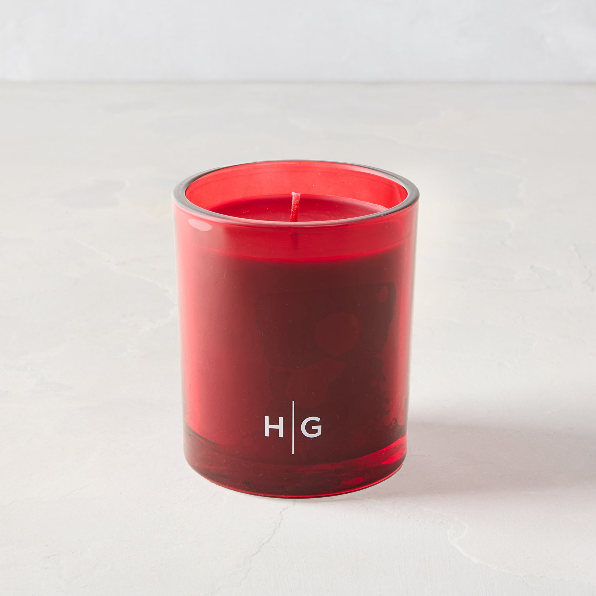 Hudson Grace Winter Scented Candle in a classic red glass vessel with red wax and "HG" logo.