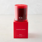 Hudson Grace Winter Scented Candle in a red glass vessel with red wax, on a matching red gift box.