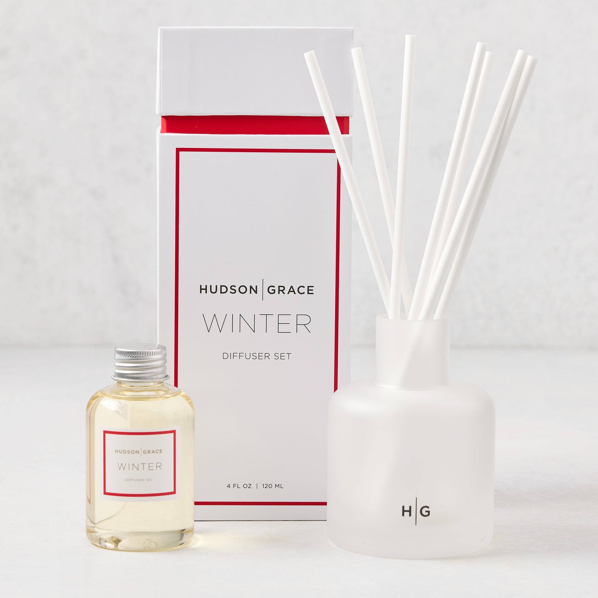 Hudson Grace Winter Scented Reed Diffuser Oil Refill bottle, white box, and frosted glass diffuser with reeds.