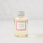 Hudson Grace Winter scented reed diffuser oil refill, clear glass bottle with silver cap, white label.