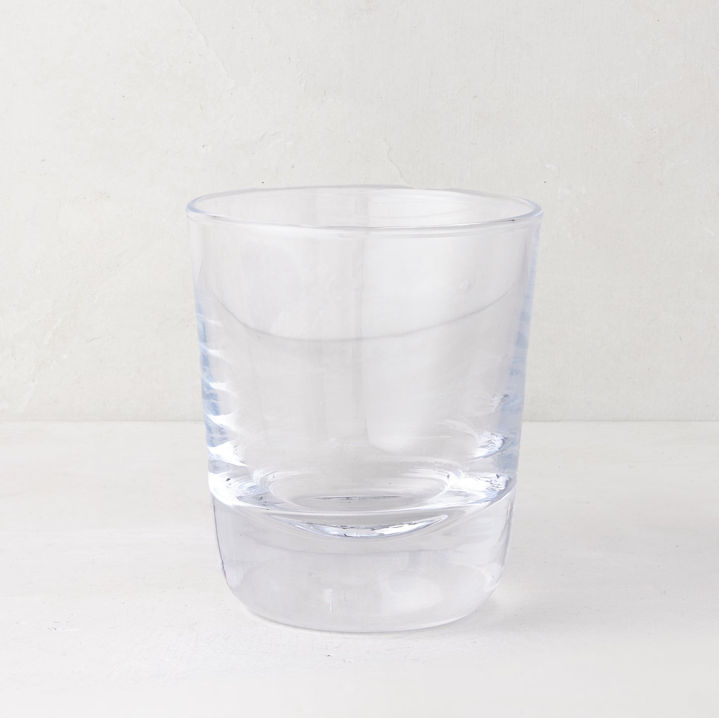 Clear, chunky Hudson Stemless Glass, 3.5"Dia x 4"H, with a thick base, on a white surface.