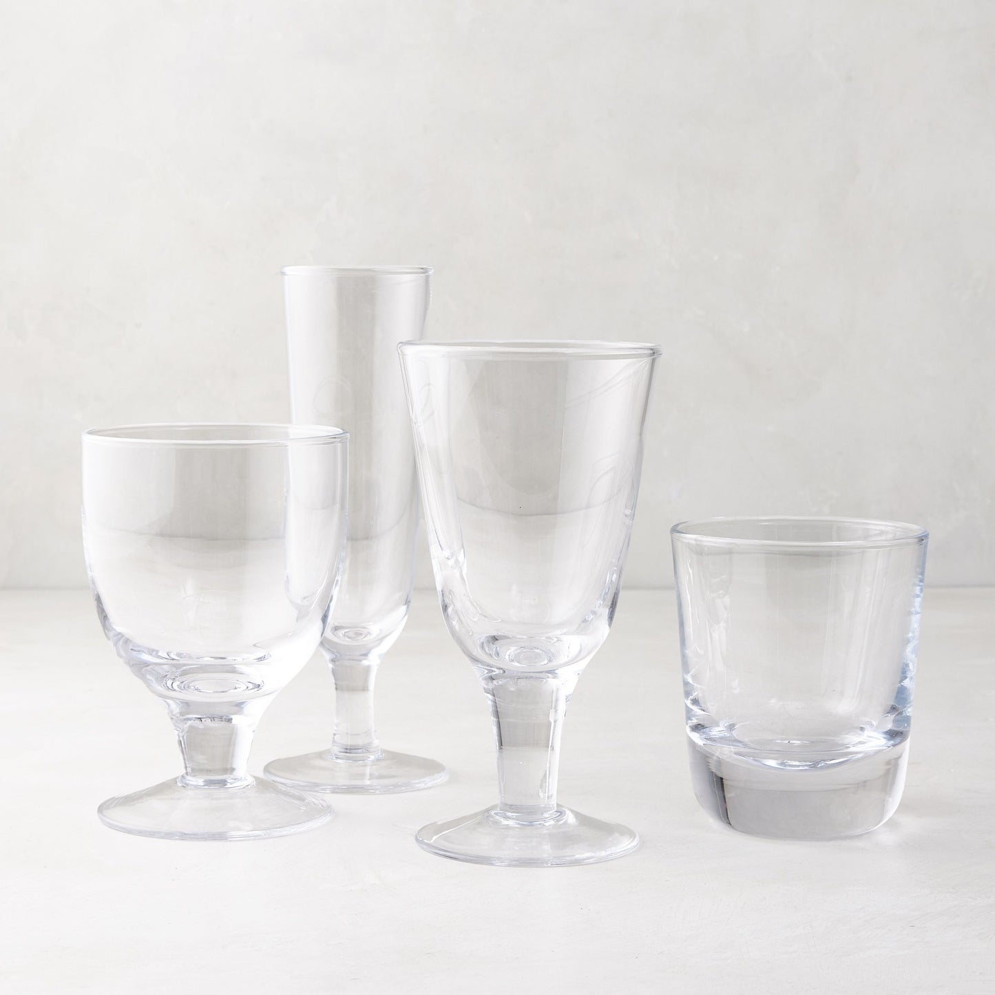 Clear Hudson Water Goblet, Henri Glassware, and other clear glasses on a white surface.
