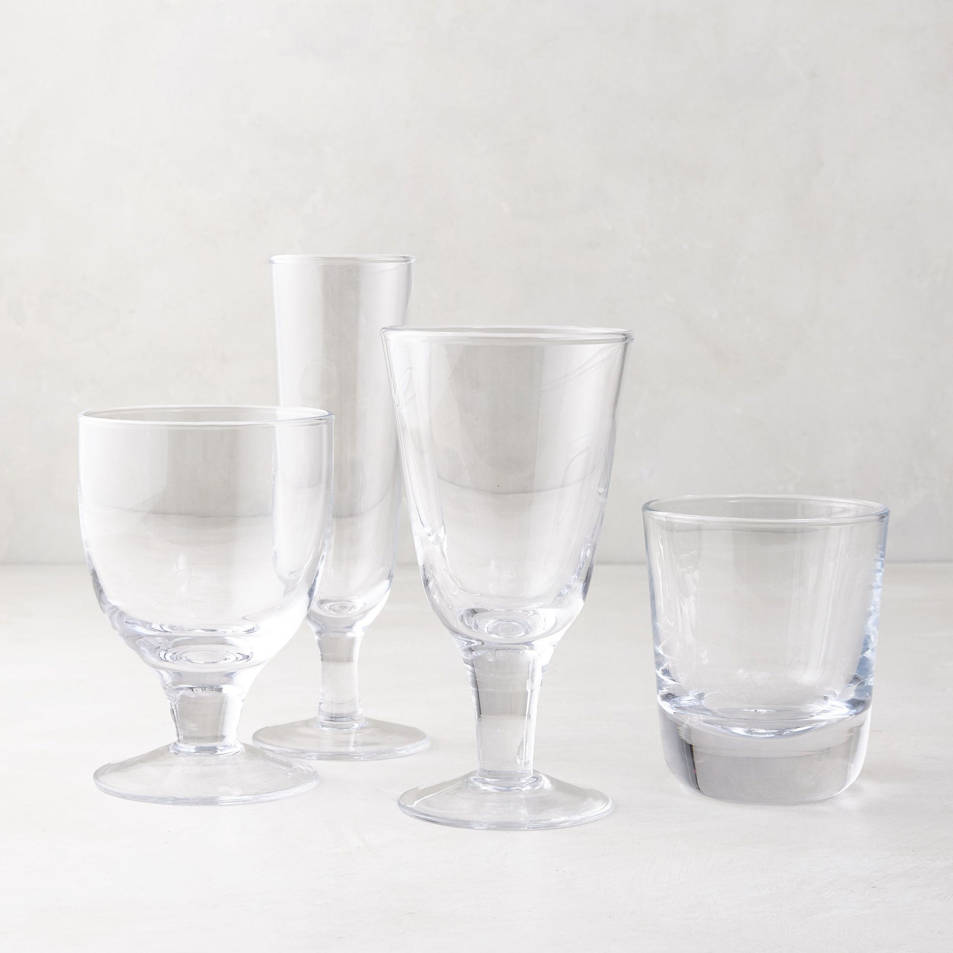 Clear Hudson Water Goblet, Henri Glassware, and other clear glasses on a white surface.