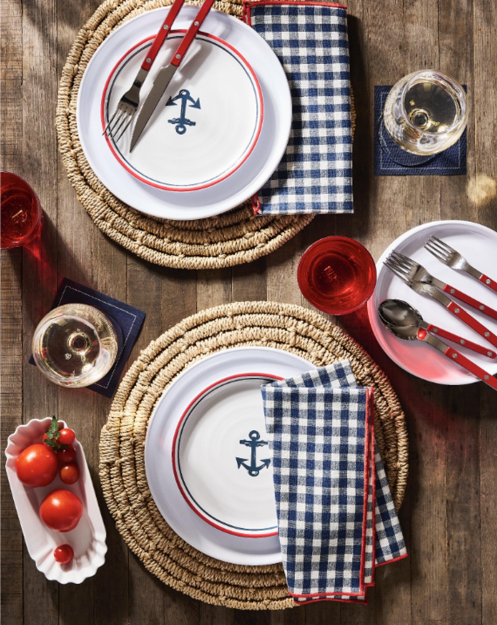 Hudson Grace red, white, and blue Nautical-themed table setting with melamine plates, cutlery, and checkered napkins on a wooden table.
