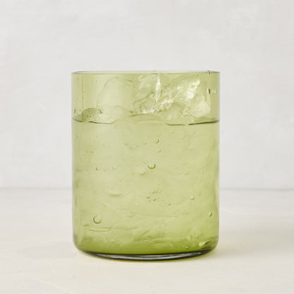 Hugo Aloe Green Double Old Fashioned Glass, filled with ice and a clear drink. Handmade glass, 3.25"Dia x 4"H.