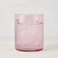 Hugo Fig Double Old Fashioned Glass, a sleek, sturdy pink glass with ice and a sparkling drink.