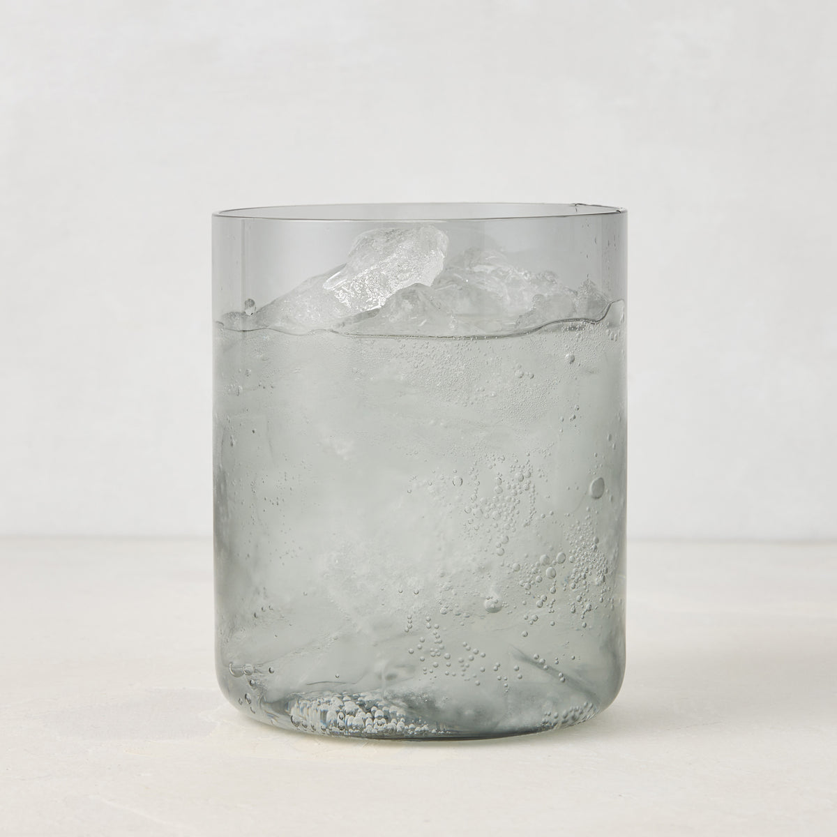 Hugo Smoke Grey Double Old Fashioned Glass with ice and drink, 3.25"Dia x 4"H, handmade in Poland.