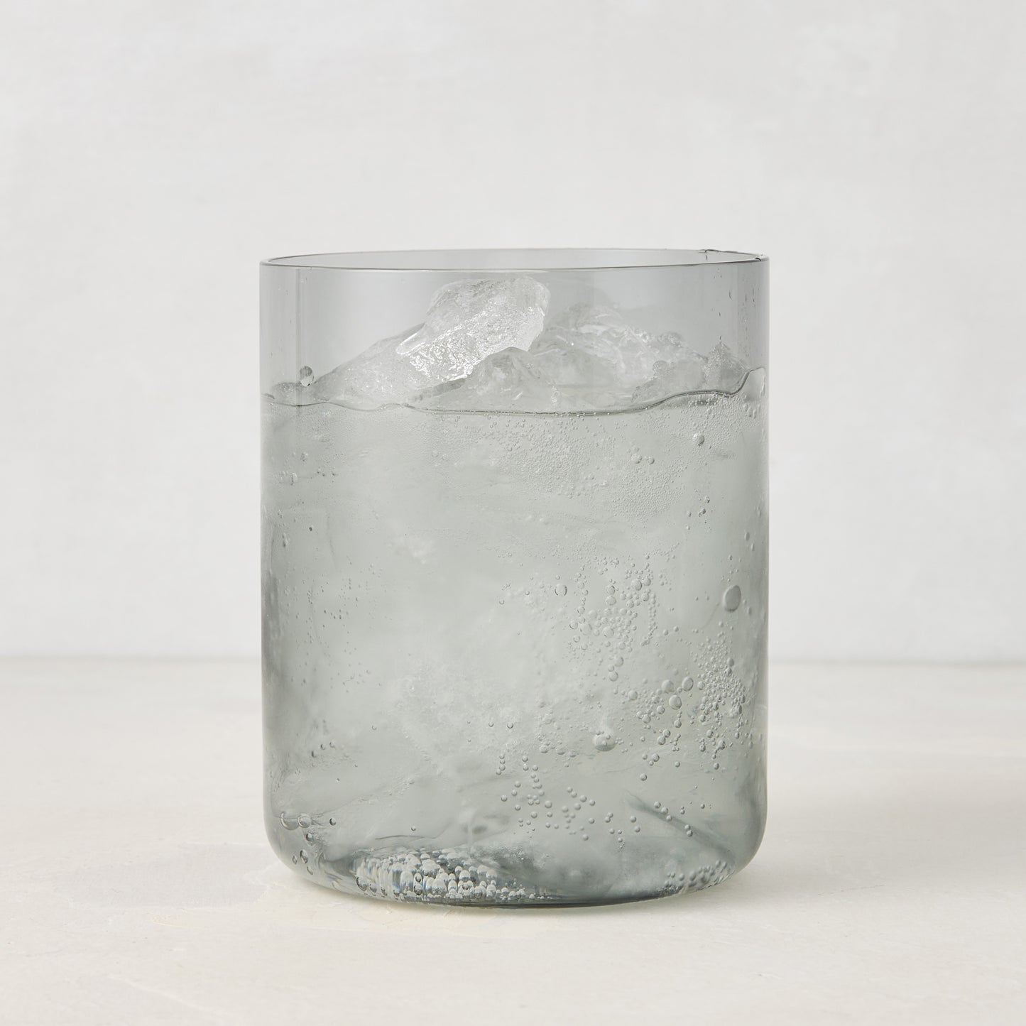 Hugo Smoke Grey Double Old Fashioned Glass with ice and drink, 3.25"Dia x 4"H, handmade in Poland.