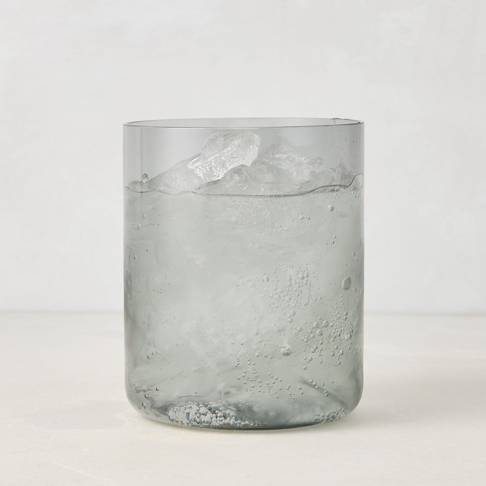 Hugo Smoke Grey Double Old Fashioned Glass with ice and drink, 3.25"Dia x 4"H, handmade in Poland.