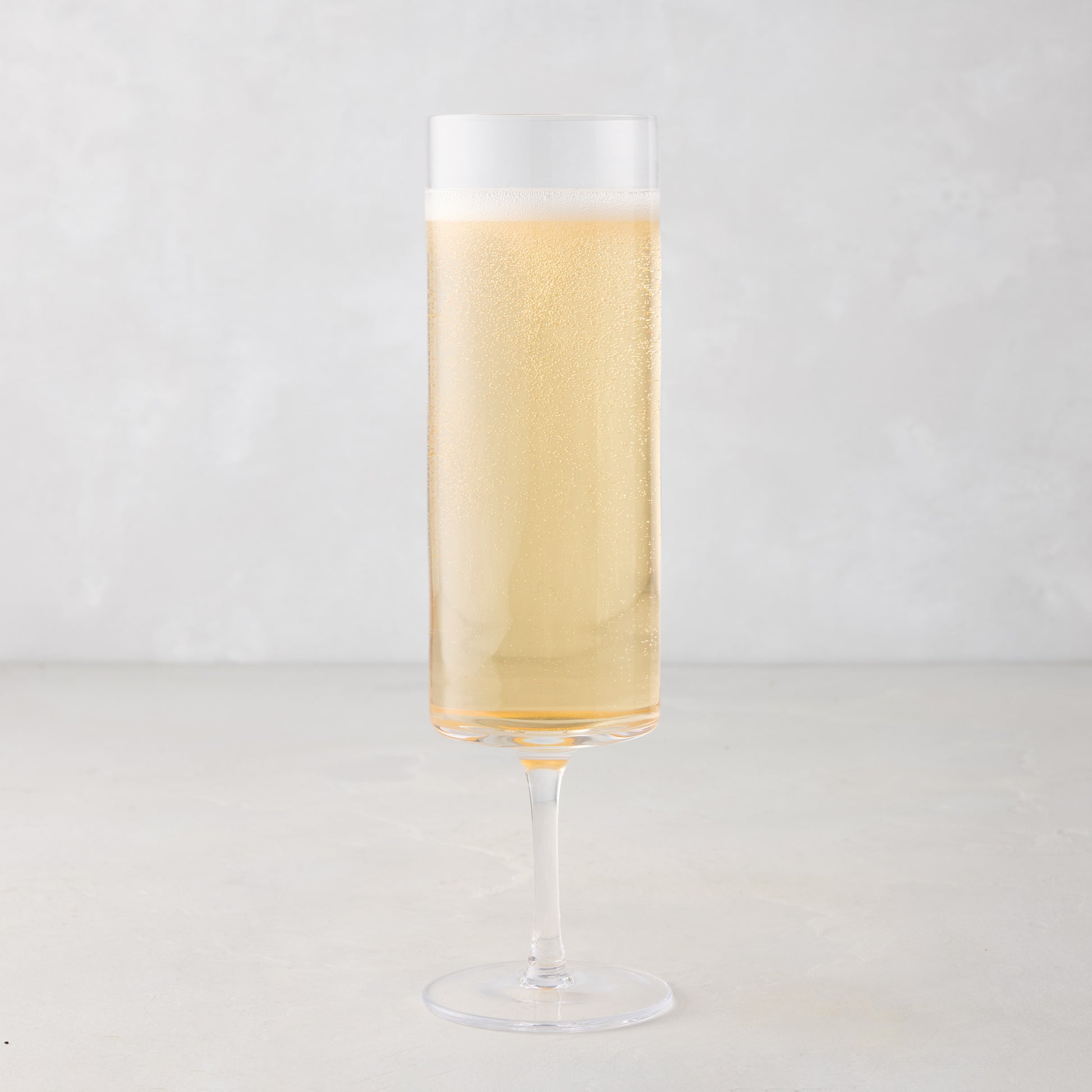 Hugo Stemmed Champagne Flute, clear glass, filled with bubbly golden champagne, 2"Dia x 8.3"H.