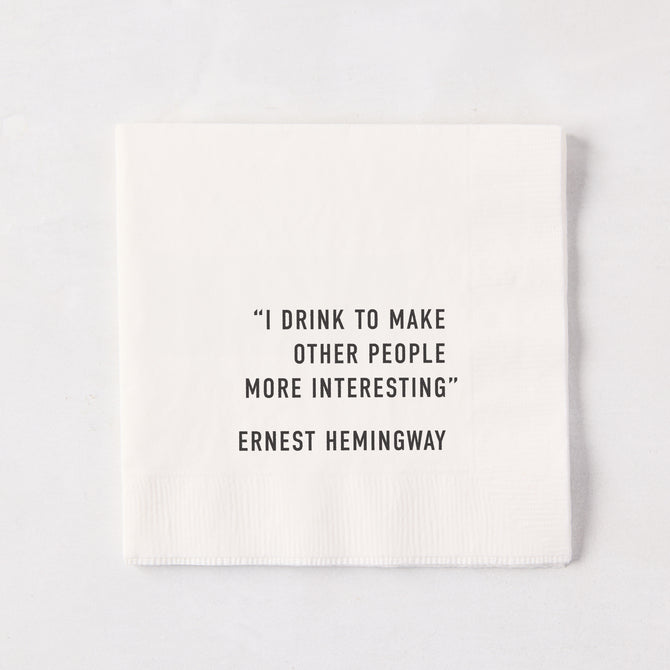 White 5.5-inch square 3-ply paper cocktail napkin with black text reading I Drink To Make Other People Interesting.