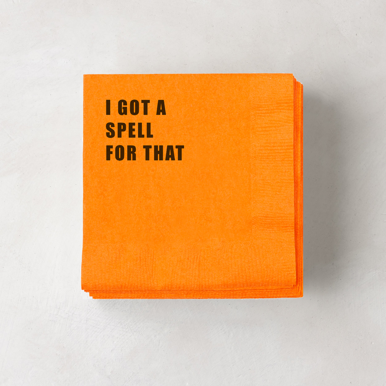 Orange paper cocktail napkins with "I GOT A SPELL FOR THAT" in black text, 5.5" square.