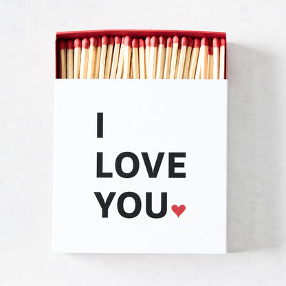 White matchbox with I Love You text and red heart, filled with long wooden matches featuring red tips.