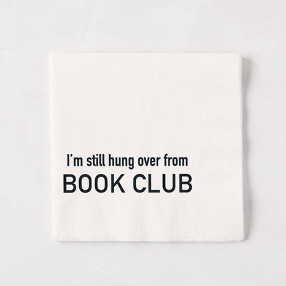 White 5.5-inch square 3-ply paper cocktail napkin with black text reading I'm still hung over from BOOK CLUB.
