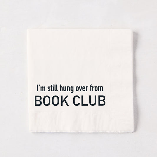 White 5.5-inch square 3-ply paper cocktail napkin with black text reading I'm still hung over from BOOK CLUB.
