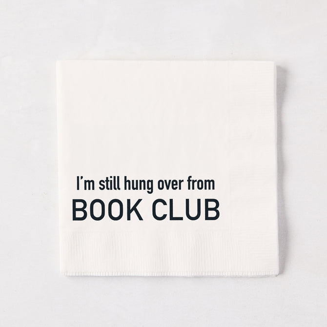White 5.5-inch square 3-ply paper cocktail napkin with black text reading I'm still hung over from BOOK CLUB.