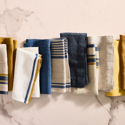 Indigo blue boat stripe natural cotton linen napkin, folded with other striped and solid napkins.