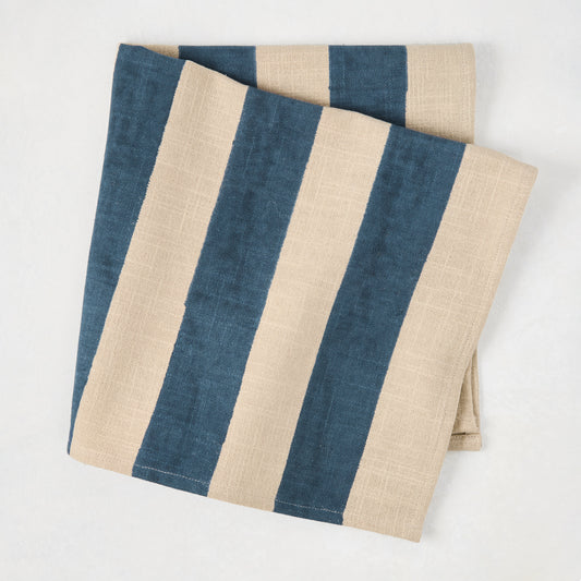 Folded Indigo Blue Hampton Stripe Natural Cotton Napkin, 22" square, with wide blue and khaki stripes.