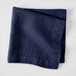 Folded Indigo HG Signature hand-dyed linen napkin, 22-inch square, with mitered corners.