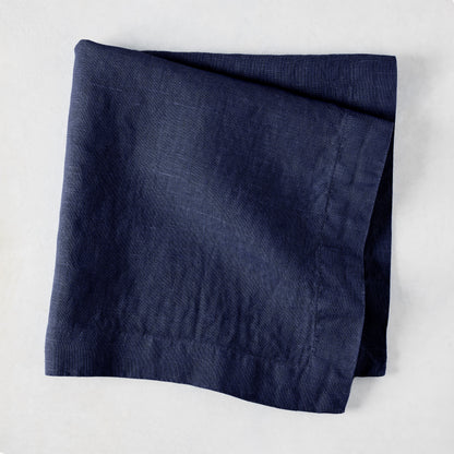 Folded Indigo HG Signature hand-dyed linen napkin, 22-inch square, with mitered corners.