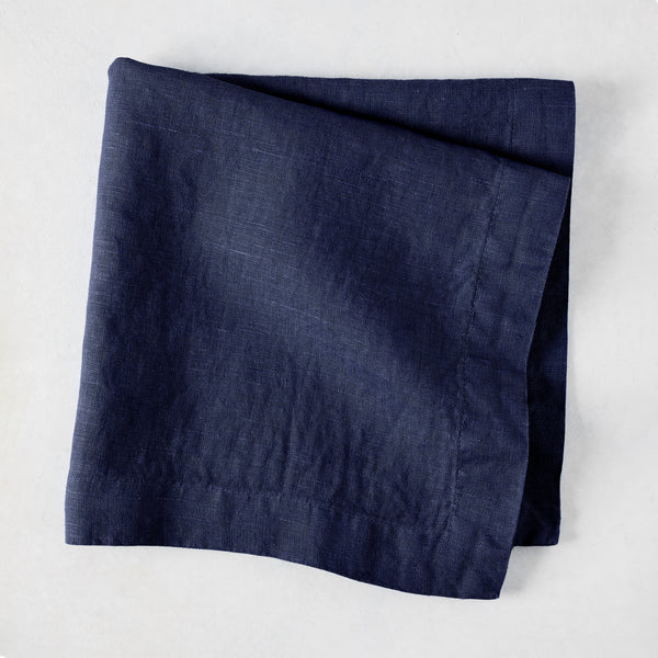 Folded Indigo HG Signature hand-dyed linen napkin, 22-inch square, with mitered corners.