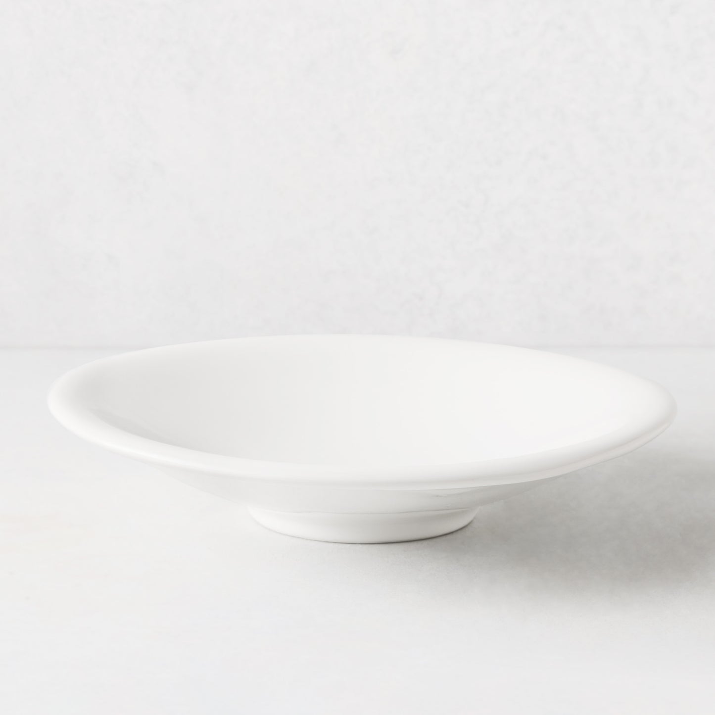 White individual ceramic pasta bowl, 10.75" diameter, shallow and wide, with a subtle footed base.