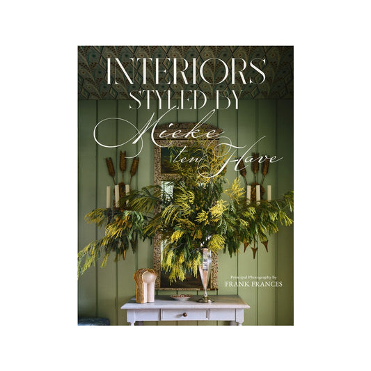 Hardcover book "Interiors: Styled by Mieke ten Have" with green walls, mirror, and floral arrangement.