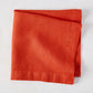 Folded International Orange HG Signature hand-dyed linen napkin, 22-inch square.