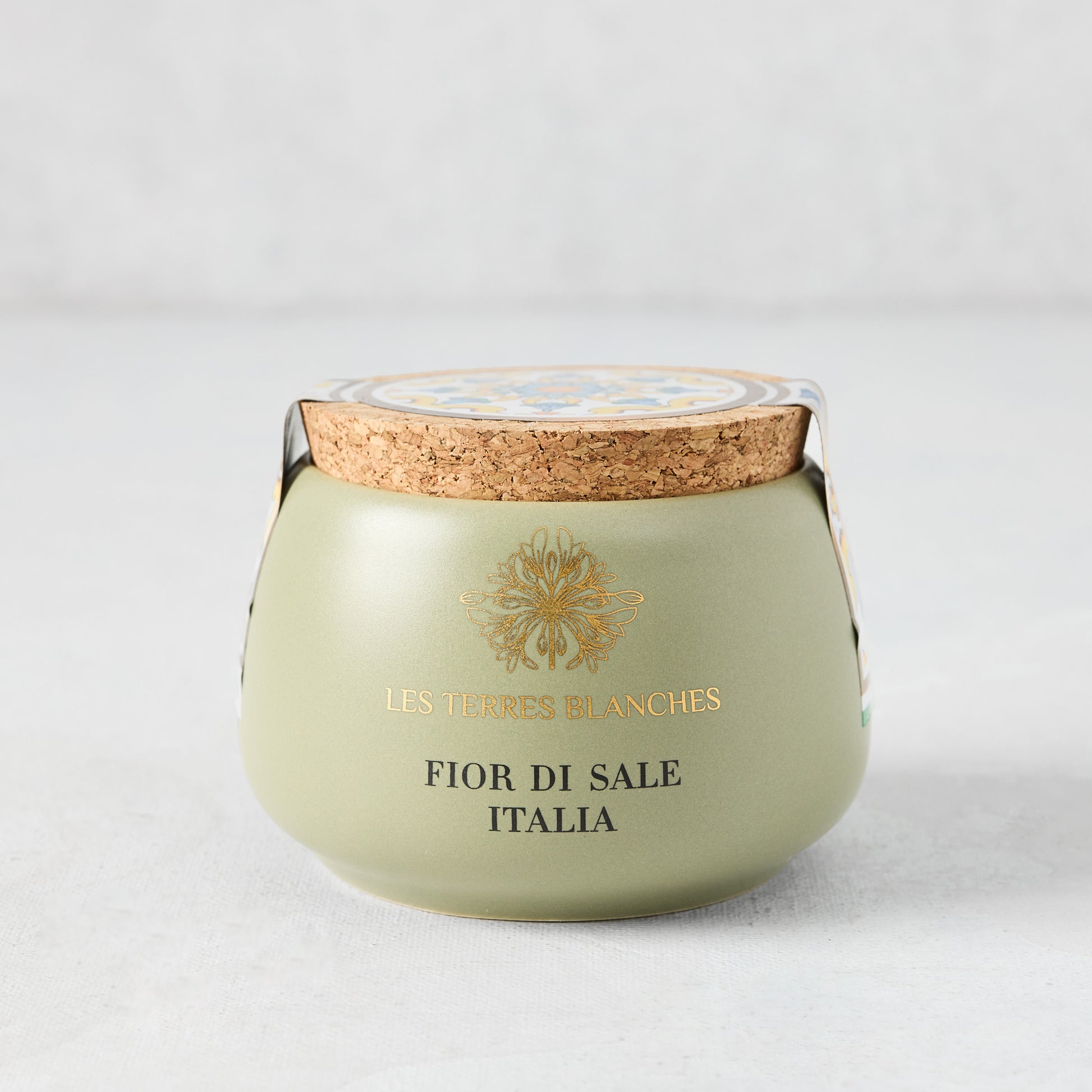 Italia Fleur De Sel salt in a green artisanal ceramic pot with a natural cork lid and gold text.