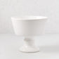 Italian white ceramic compote, 9" Dia x 8" H, with a modern footed bowl design and creamy glaze.