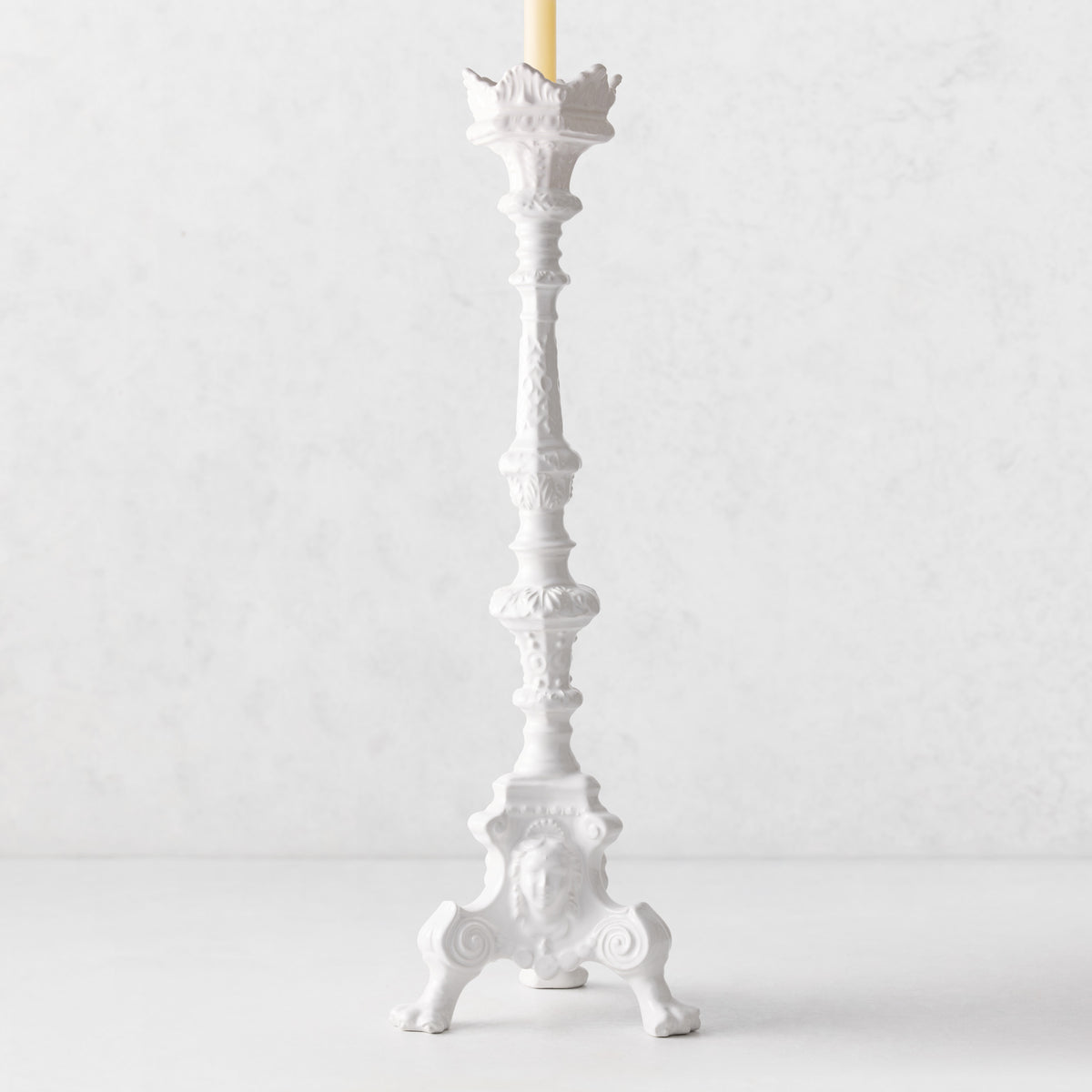 20.5-inch tall white ceramic footed candlestick with ornate antique-style detailing and a taper candle.