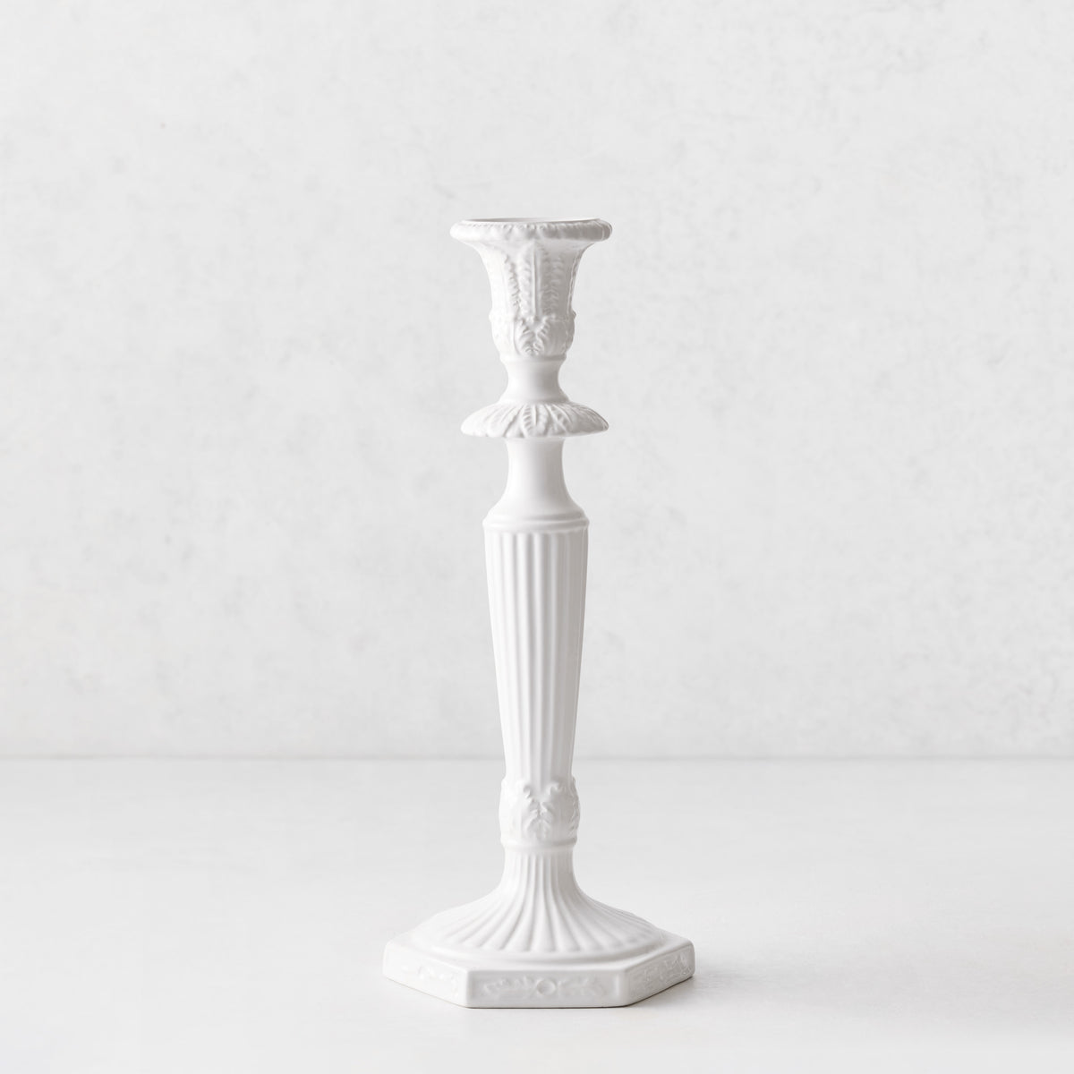 Small white Italian ceramic candlestick with intricate antique-style detailing and a fluted base, 13 inches tall.