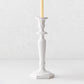 Small white Italian ceramic candlestick with intricate antique-style detailing and a taper candle.