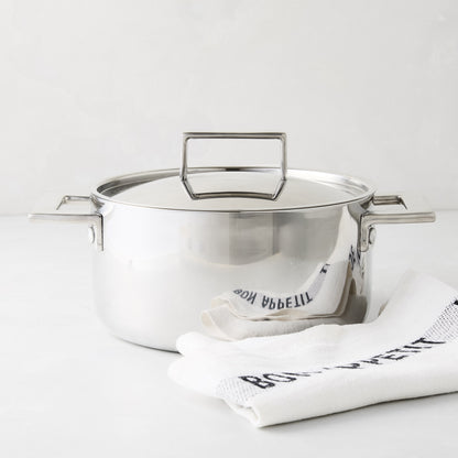 Italian 3-liter stainless steel casserole pot with lid and handles, beside a white "Bon Appetit" towel.
