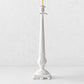 Tall white Italian ceramic candlestick with intricate antique-style detailing and a tapered silhouette.