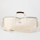 Ivory canvas garden tote bag with grey interior, brown leather handle grips, and long shoulder strap.