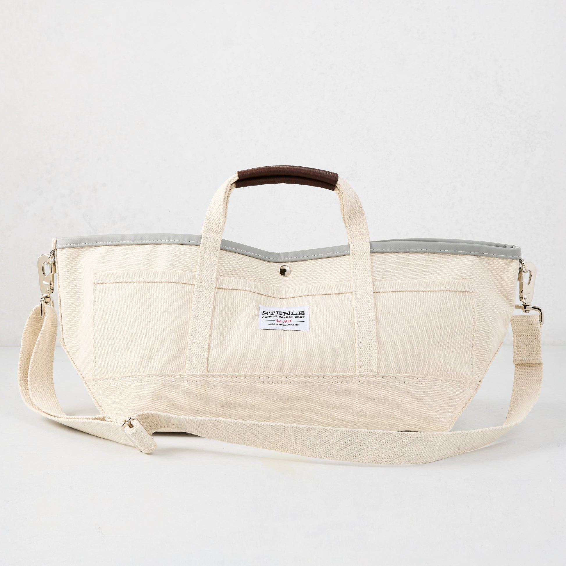 Ivory canvas garden tote bag with grey interior, brown leather handle grips, and long shoulder strap.