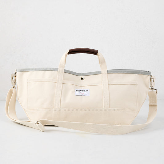 Ivory canvas garden tote bag with grey interior, brown leather handle grips, and long shoulder strap.