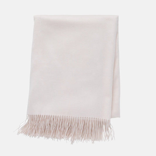 Ivory cashmere throw blanket, folded, with classic fringe.
