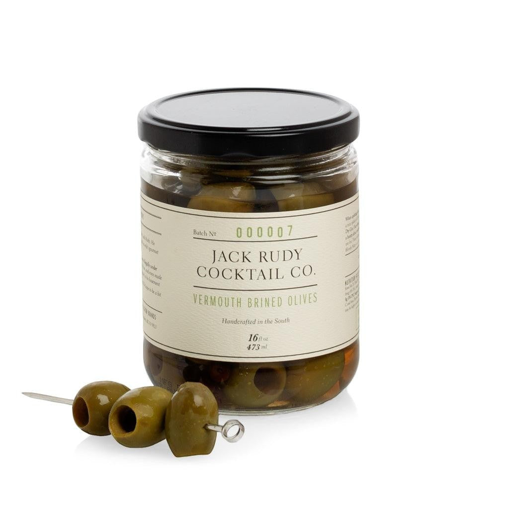 Jack Rudy Cocktail Co. Vermouth Brined Olives in a 16 fl. oz. glass jar with three olives on a cocktail pick.